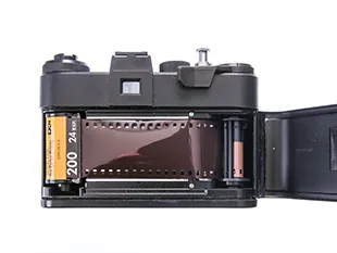 Top view of a black Zenit ET camera with the film rewind knob highlighted in red